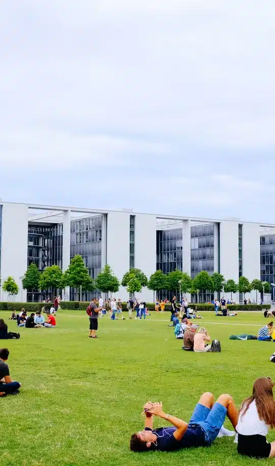 University campus with a brick path leading to a glass-fronted student union building