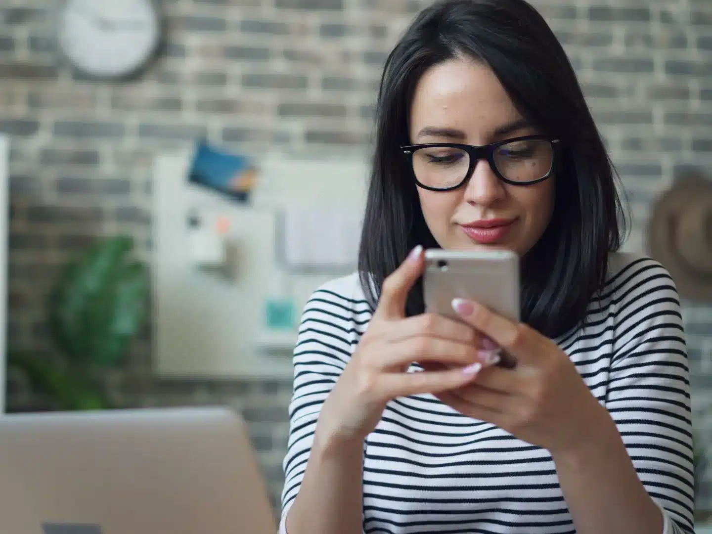 A store owner checking her visitor traffic on her smartphone from the office